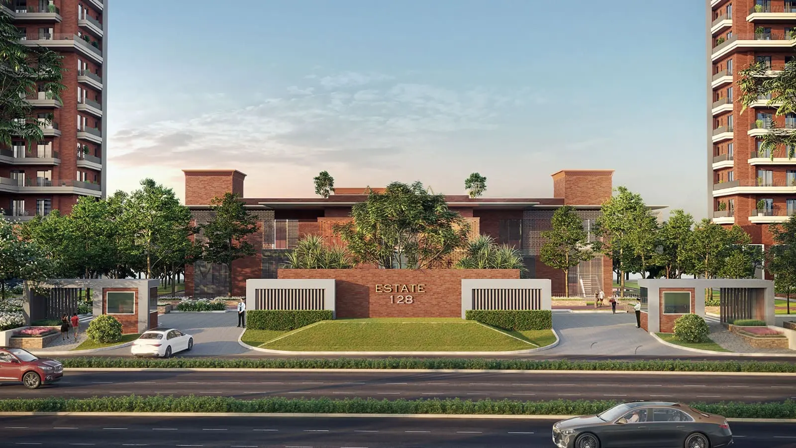 Grand front entrance gates of Estate 128 featuring modern brick walls, a manicured green lawn, and luxury high-rise towers on either side
